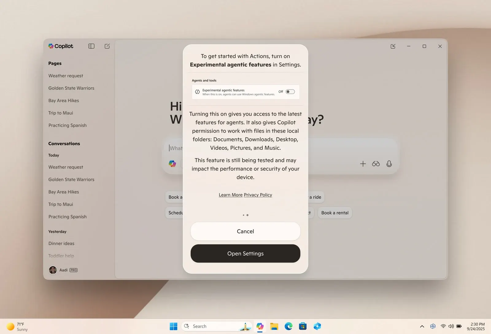 Zrzut pulpitu Windows 11 w jasnym motywie z wyśrodkowanym paskiem zadań na dole. Na wierzchu okno aplikacji Copilot z listą wcześniejszych rozmów po lewej i komunikatem po prawej, proszącym o włączenie eksperymentalnych funkcji agentowych w ustawieniach, z przyciskami Cancel i Open Settings.